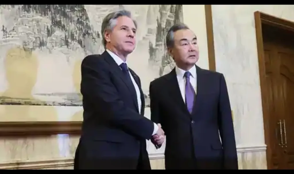 Blinken and China Diplomat shaking hands