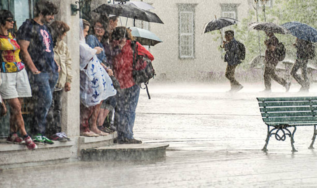 group-of-people-hide-from-heavy-rain-under-a-building