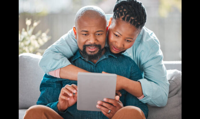 Woman-hugging her father while-he-uses-a-digital-tablet