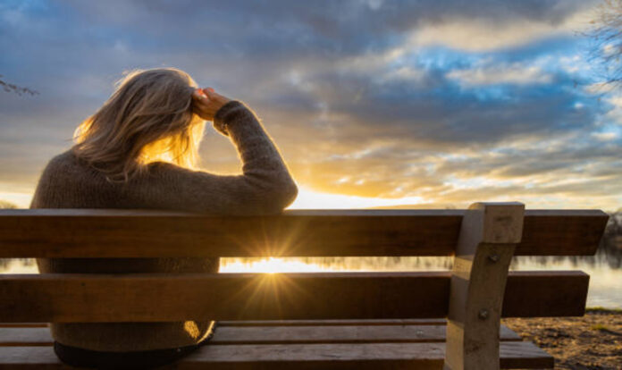 Women sitting on bench and watching sunset