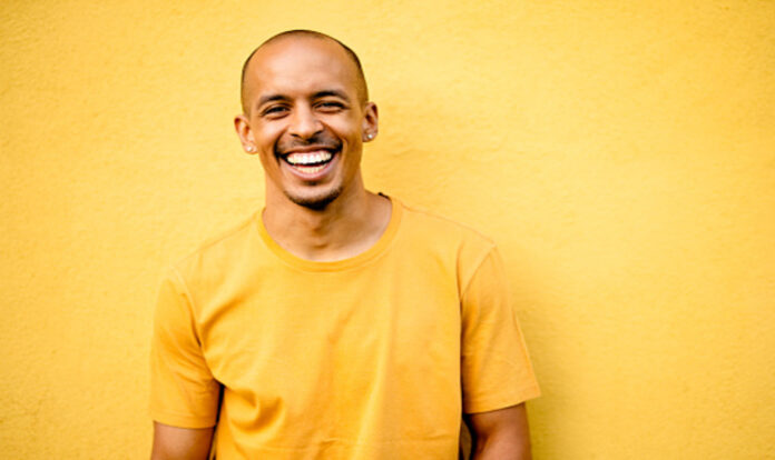 Men laughing wearing yellow tshirt on yellow background