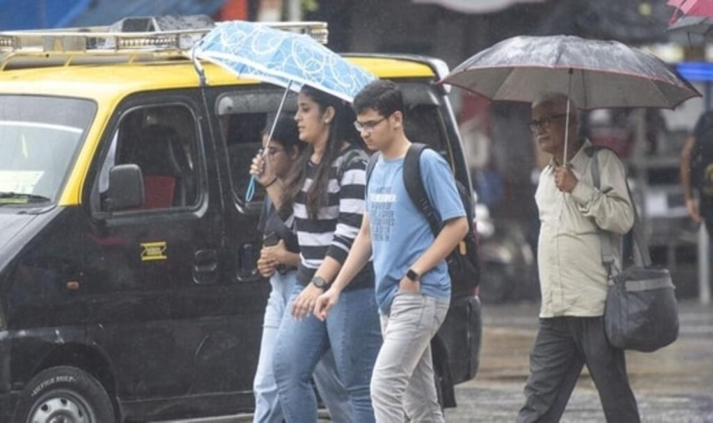 Pedestrians holding umbrella and walking in Monsoon
