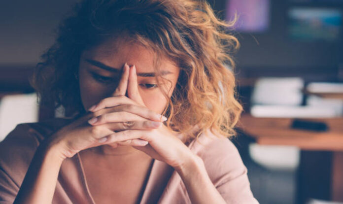 Woman stressed leaning hand on head