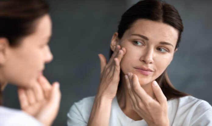 Woman looking at her skin in mirror