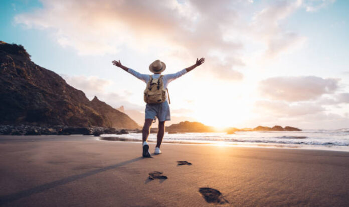 Man arms outstretched towards sunset