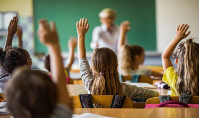 Students raising hands in Classroom