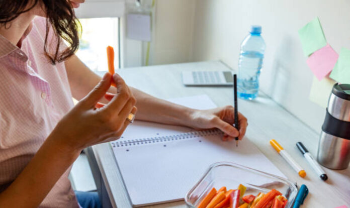 Woman writing while eating