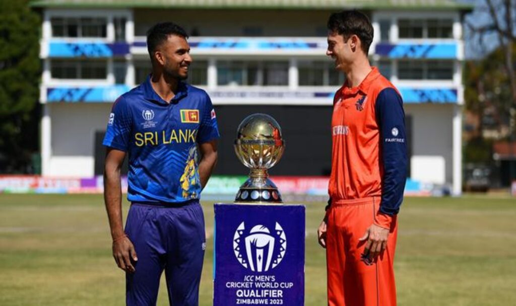 Players standing on either side of trophy