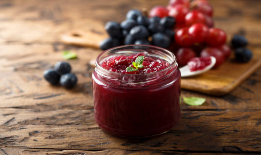 Homemade jam with berries in wooden background