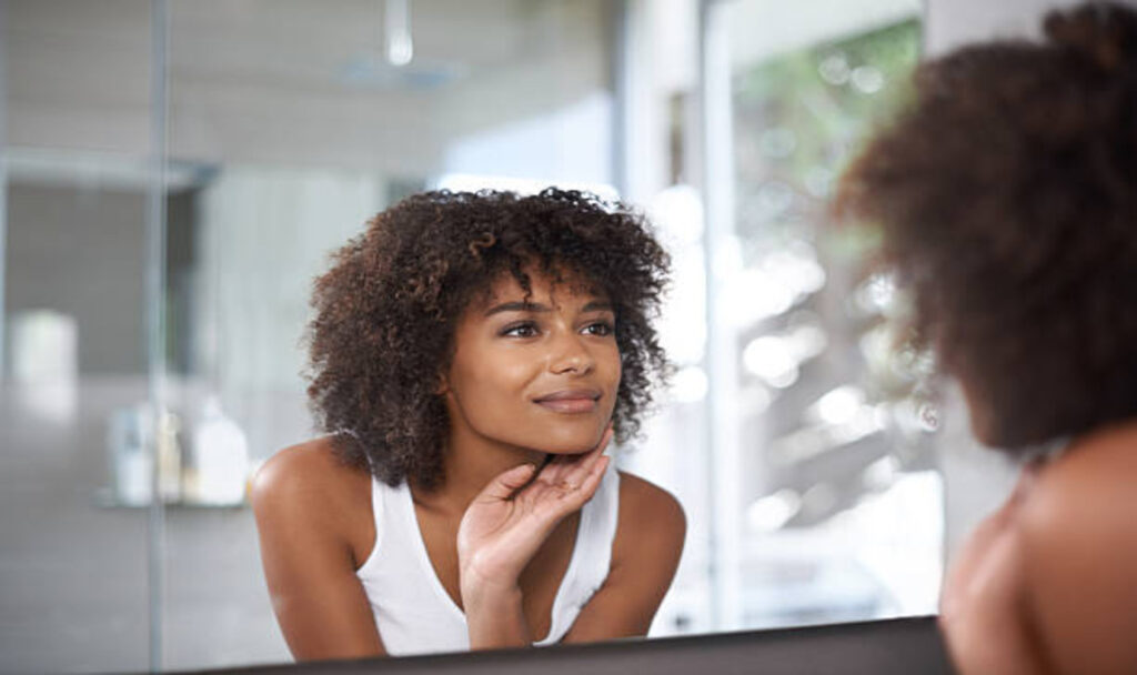 Woman looking herself in mirror